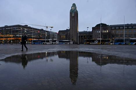 Suuri vesilätäkkö Rautatientorilla Helsingin keskustassa torstaina. Vesisade muuttuu pääkaupunkiseudulla iltapäivän ja alkuillan mittaan lumisateeksi, ja illalla päästään jo pakkaslukemiin. 