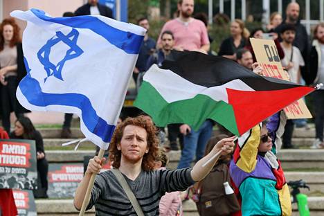 Opiskelija piteli Israelin ja Palestiinan lippuja Tel Avivissa maanantaina.