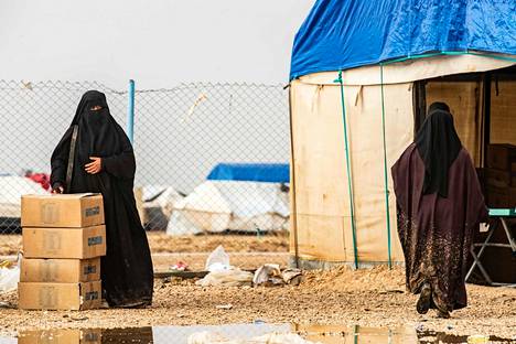 Poliisi on hankkinut al-Hol -leirin suomalaisista tietoa siinä määrin kuin se on ollut mahdollista. Nainen seisoo avustuspakkausten vieressä al-Holin leirissä.