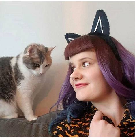 Kirjastonhoitaja Marjo Mannila tekee Soturikissat-livelähetyksiä Instagramiin yhdessä kissojensa Nellin ja Nekun kanssa. Kuvassa Mannilan kanssa Nekku.
