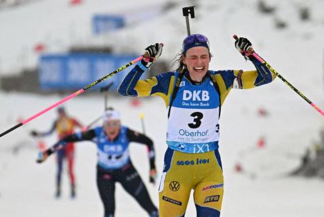 Ruotsin Hanna Öberg iloitsee takaa-ajokisan voittoa ennen takaa tulevia Norjan Ingrid Tandrevolda ja Ranskan Julia Simonia.