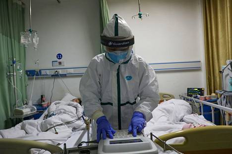 Sairaalan työntekijä ja potilaita Caidianin sairaalan eristysosastolla Wuhanin alueella helmikuun alussa.