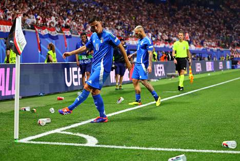 Italy's Giacomo Raspadori (left) and Federico Dimarco kick plastic cups off the field during the match against Croatia.
