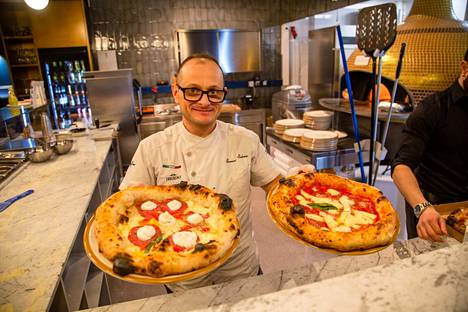 Ravintoloitsija Severino Salzano paistaa pizzoja avokeittiössä, jonka muhkea uuni kuumenee kaasulla.