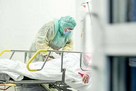 Suojavarustukseen pukeutunut hoitaja ottaa näytettä Turun yliopistollisessa sairaalassa.