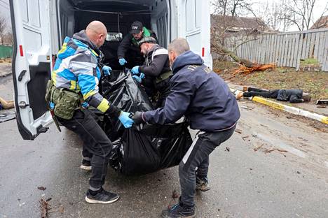 Ukrainalaiset vapaaehtoiset siirsivät Butšan kadulle jääneitä ruumiita pois pakettiautolla sunnuntaina.