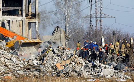 Pelastusmiehet raivaavat Makijivkassa rakennusta, jossa kymmeniä venäläissotilaita kuoli Ukrainan iskussa. 