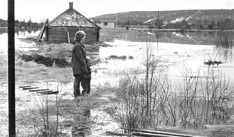 Rovaniemen kupeessa Saarenkylässä asuvalle rouva Kirsti Juopperille ja 3-vuotiaalle Kristiinalle Ounasjoen tulva merkitsee satojen metrien kiertelyä pitkin pellonpientareita. Silti tielle ei pääse kuivin jaloin.
