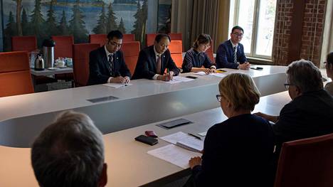 Kunshanin delegaatio istui toisella puolella pöytää, suomalaiset toisella puolella.