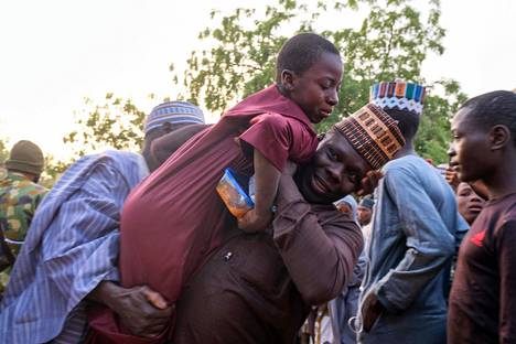Mies kannatteli lähes viikon siepattuna ollutta poikaansa Katsinassa, Nigeriassa 18. joulukuuta.
