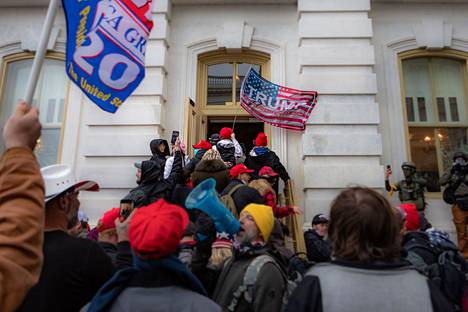 Trump-lippuja kantavat protestoijat rynnivät Capitoliin 6. tammikuuta 2021.
