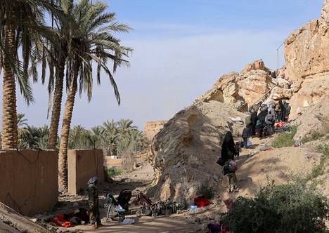 Isis-taistelijoita ja heidän perheitään kävelemässä Baghuzin kylästä antautumisen jälkeen maaliskuussa 2019.