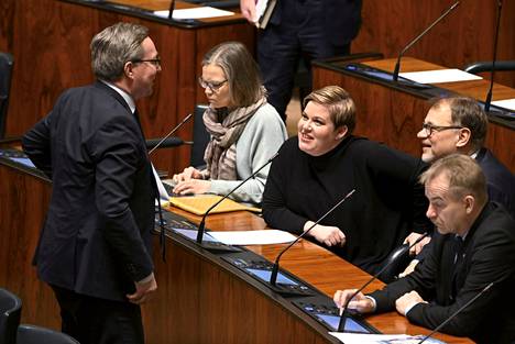 Keskustan Mika Lintilä (vas.) ja Annika Saarikko sekä Juha Sipilä keskustelevat eduskunnan täysistunnossa Helsingissä 10. helmikuuta 2023.