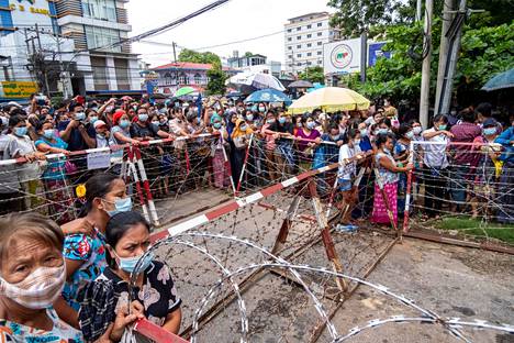 Ihmiset odottivat vapautettuja läheisiään Inseinin vankilan edessä Yangonin kaupungissa Myanmarissa 30. kesäkuuta.