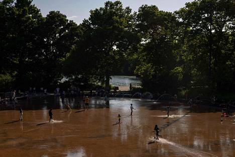 People spent time under the water jets in Brooklyn, New York on Thursday.
