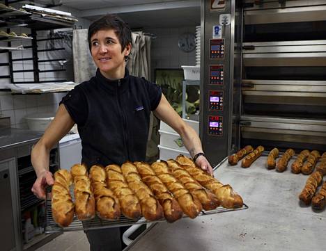 Priscilla Hayertz otti patonkeja uunista leipomossaan Pariisin Montmartrella. Viljan ja energian hinnannousut tuntuvat leipomon arjessa.