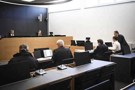 Syytetty (vas.), hänen asianajajansa ja syyttäjät (oik.) moottoripyöräjengi Cannonballin oikeudenkäynnin pääkäsittelyn alkaessa Päijät-Hämeen käräjäoikeudessa Lahdessa 27. huhtikuuta 2022. 