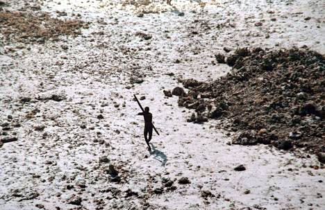 Intian rannikkovartioston julkaisemassa kuvassa vuodelta 2004 sentinel-heimon jäsen tähtää jousipyssyllään ylitse lentävää rannikkovartioston helikopteria.