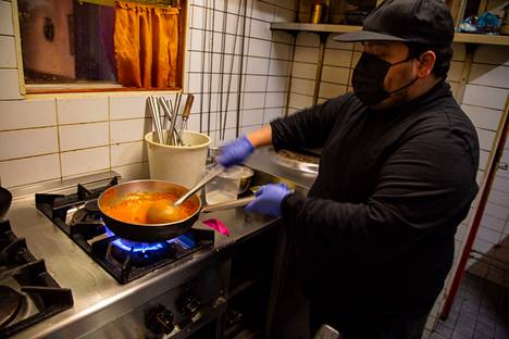Santosh Pandey valmistaa butter chicken -annosta Rani Mahal -ravintolassa Sörnäisissä.