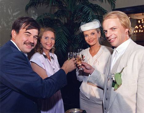 In the Metsolat series episode Arkea ja juhlaa (1993), a wedding was celebrated.  The newly married couple Helena and Erkki Metsola (Anu Hälvä and Kari Hakala, right) are congratulated by Helena's brother Kari Kaukovaara (Juha Hyppönen) and Erki's sister Eeva Metsola (Katriina Honkanen).