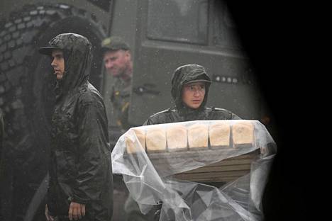 Российские солдаты несут хлеб во время учений “Восток-2022”. В них принимает участие более 50 тысяч военнослужащих и несколько про-российских стран, включая Китай. 6 сентября 2022 года. Фото: Кирилл Кудрявцев / AFP