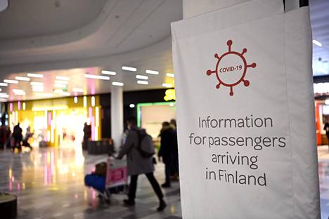 Matkustajille tiedotettiin koronaohjeista Helsinki-Vantaan lentoasemalla joulukuussa 2021. 