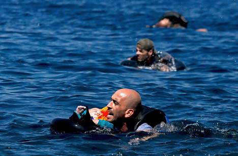 Syyrilainen pakolainen ui pienen lapsen kanssa kohden Lesboksen saarta syyskuussa.