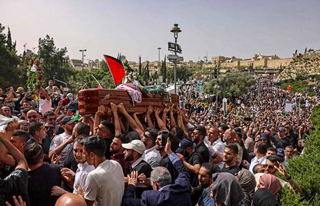 Palestiinalaiset kantavat toimittaja Shireen Abu Alekhin arkkua kirkolta hautausmaalle perjantaina Jerusalemissa.