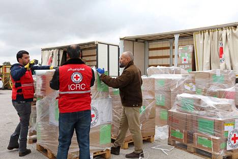 Punaisen ristin työntekijät pakkaavat avustustarvikkeita Sudaniin Jordanian pääkaupunki Ammanissa sunnuntaina.