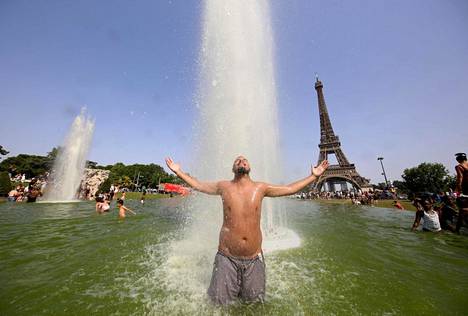 Mies vilvoitteli Trocadéron suihkulähteessä Eiffel-tornin edustalla Pariisissa kesäkuussa.