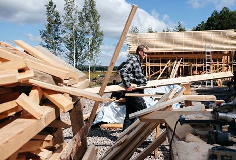 Matti Vanhanen carries boards at a building site in Lepsämä on July 31, 2020.