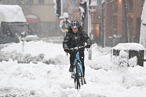 Pyöräilijä keskellä lumimyrskyä Tukholmassa maanantaina.
