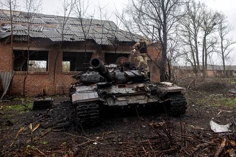 Ukrainalaissotillas käveli tuhoutuneen venäläisen panssarivaunun päällä Mala Rohan kylässä Harkovan alueella viime viikolla.