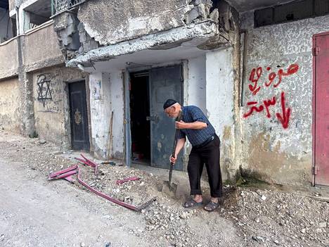 A Palestinian man cleaned the front of his house in Jenin on the West Bank on Friday.