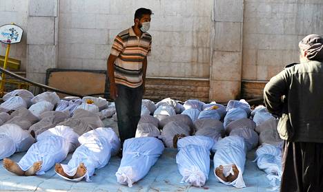 Syyrialaiset aktivistit tutkivat oletettujen kemiallisten aseiden uhrien ruumiita Damaskoksessa.