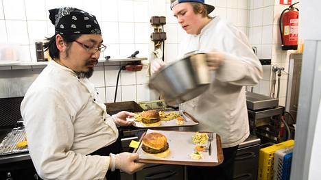Hampurilaiset käyvät nyt lounaasta. Jung Nguyen (vas.) ja Vilmeri Mikkonen valmistavat hampurilaisia ravintola Bites Vallilassa Helsingissä.
