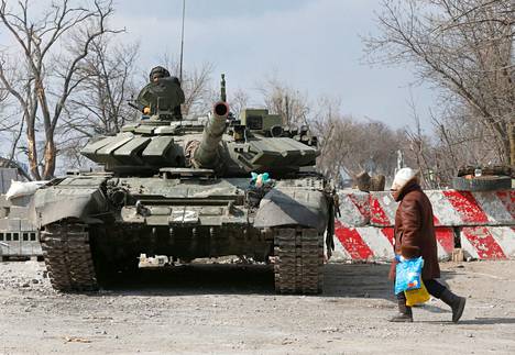 Paikallinen asukas käveli panssarivaunun editse Mariupolissa perjantaina. Kuvaajan mukaan panssari kuului separatistijoukoille.