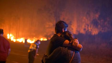 Ihmiset lohduttivat toisiaan metsäpalon laidalla O Ventossa, Espanjan itsehallintoalue Galiciassa 5. elokuuta.
