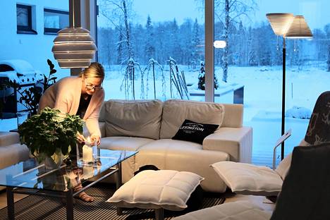 Anne Seurujärvi sytyttää kynttilöitä villasukat jalassa kotonaan Ivalojoen rannalla.