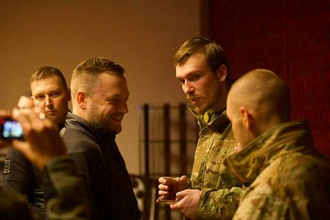 Ukrainalaisen Azovin rykmentin komentaja Denys Prokopenko (kuvassa toinen oikealta, teelasi kädessä) puhui sotilastovereidensa sekä Ukrainan sisäministerin Denys Monastyrskyn (edessä vas.) kanssa keskiviikkona. Kuvauspaikka on tuntematon.