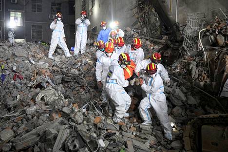 Pelastustyöntekijät kantoivat torstaiaamuna elävänä löydettyä ihmistä sortuneen talon raunioista Changshassa.