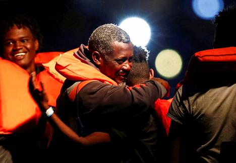 Välimerestä pelastetut ihmiset iloitsivat, kun heidät toimitettiin merivoimien aluksella Maltalle lauantaina.