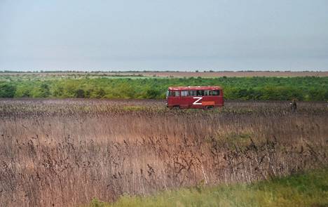 Автобус с буквой Z едет по полям Херсонской области. Фотография сделана во время пресс-тура, организованного российской армией 20 мая. Фото: Ольга Мальцева / AFP