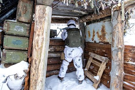 Ukrainalaissotilas kevyen konekiväärin kanssa tuliasemassa Avdiivkassa Donetskin keskustasta pohjoiseen tammikuussa 2022.