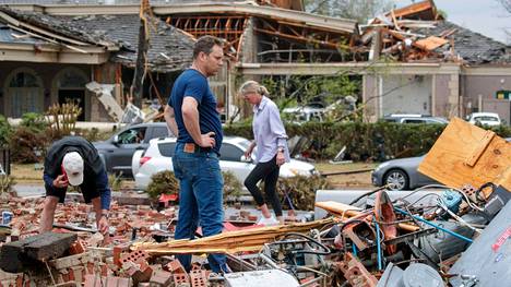 Kris French (kesk.) ja hänen perheensä etsi autopesulansa raunioista valvontakameraa Little Rockin kaupungissa perjantaina. Valvontakameran videolle on tallentunut kaupunkia tuhoava tornado.