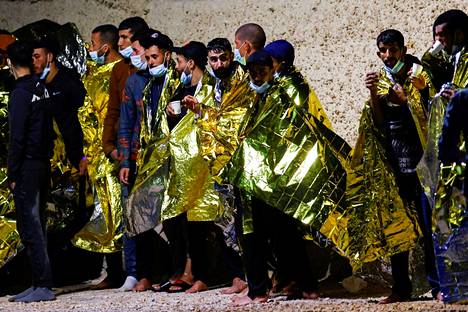 Siirtolaiset lämmittelivät satamassa Lampedusan saarella Italiassa 21. kesäkuuta.