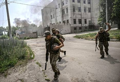 Ukrainalaisia sotilaita juoksemassa suojaan taistelussa Donbasin alueen Lysytšanskin kaupungin hallinnasta 11. kesäkuuta.