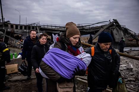 Ukrainasta pakeneva nainen kantoi vauvaansa tuhotun sillan yli Irpinissä, Ukrainassa 7. maaliskuuta. 