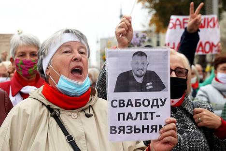 Mielenosoittaja piti kädessään oppositioaktivisti Sjarhei Tsihanouskin kuvaa protestissa Minskissä vuoden 2020 lokakuussa.