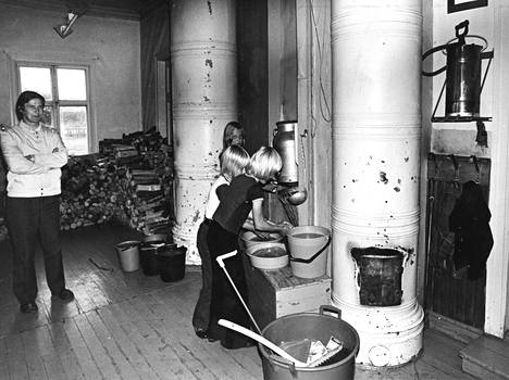 Kiviniemi school's combined hallway and social space: a stack of cracks and Sankoruisku for burns, plastic buckets for washing hands and a bucket for those who are thirsty. Arvo Silven predicts that the misery will continue for years to come.